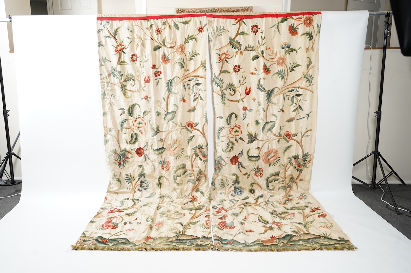 Six 20th century crewel work ‘Tree of Life’ cream linen curtains. Worked at the base in coloured wools depicting a pastoral scene of a shepherd playing a flute amongst sheep, deer, squirrels and flowers with a dog chasin